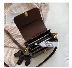 Structure interne multicouche du sac bandoulière vintage en cuir marron avec accessoires
