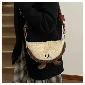 Detail van pluche schoudertas in croissantvorm met schattig borduursel en fleece textuur