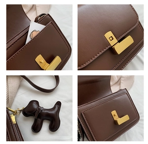 Détail du sac rétro en cuir marron avec fermoir doré et pendentif en forme de chien