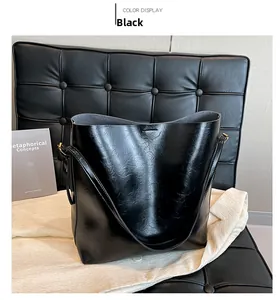 Detailansicht der großen schwarzen Tote-Bag aus Glanzleder mit breitem Gurt