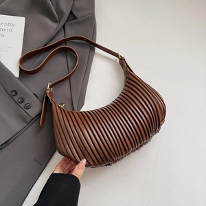 Detailed close-up of brown pleated crescent shoulder bag with high-quality PU leather texture