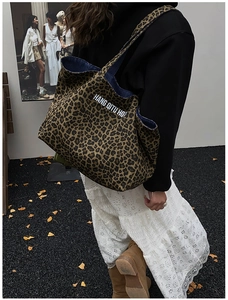 Detailed view of leopard print canvas tote bag with contrast blue denim lining and white letters