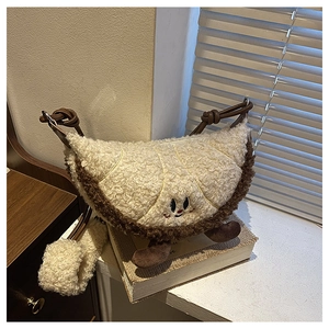 Detail van de pluizige crossbodytas in de vorm van een croissant met schattig borduursel