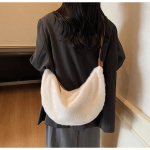 Detailed view of the soft white faux fur texture and brown faux leather strap on the bag