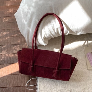Vue détaillée du sac fourre-tout en daim bordeaux avec design à rabat minimaliste