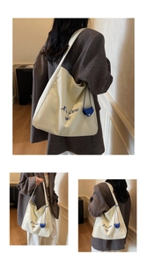 Détail du sac cabas en toile avec imprimé graphique bleu et accessoire en cuir bleu