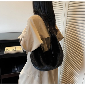 Close-up of black fuzzy faux fur hobo bag texture and elegant croissant crescent shape