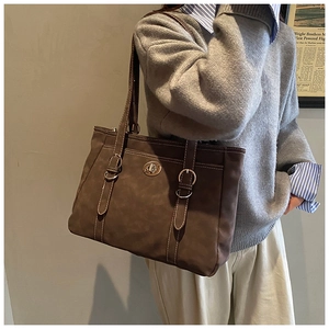 Détail du sac cabas marron vintage avec surpiqûres blanches et fermoir doré