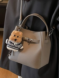 Chic brown pebbled leather bucket bag with top handle and cute puppy charm accessory