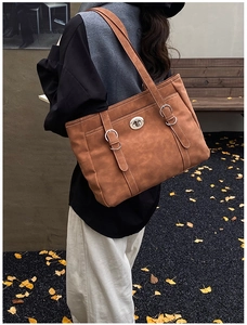 Gros plan d'un sac cabas vintage marron avec fermoir métallique et détails de fines brides