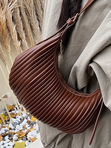 Vertical pleated brown shoulder bag in crescent shape with smooth metal zipper detail