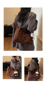 Detail of brown suede tote bag with woven shoulder strap and cute cloud charm