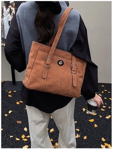 Détail du sac cabas caramel avec surpiqûres blanches et fermoir métallique argenté