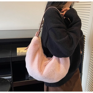 Pink plush faux fur hobo bag with adjustable leather shoulder strap on a model
