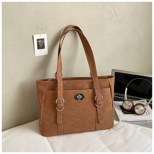 Détail du sac cabas marron en similicuir avec fermoir rotatif et anneaux en métal élégants