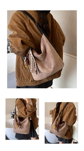 Detailed close-up showing brown suede hobo bag with teddy charm and woven strap detail