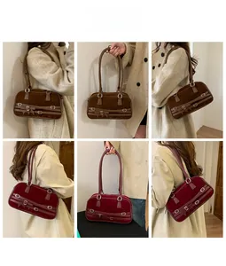 Detail view of retro bowling shoulder bag in brown and burgundy suede with belt accents