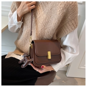 Détail du sac vintage marron foncé avec fermoir doré et pendentif en forme de chien