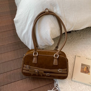 Detail of vintage dark brown suede bowling bag with buckle and long double handles