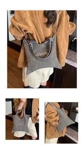 Detail of dark grey slouchy canvas tote with silver rivets and gothic metal charms