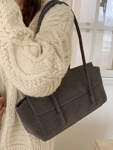 Sac fourre-tout minimaliste en suédine gris foncé porté avec un pull en tricot chaud