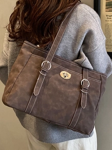 Sac fourre-tout marron foncé en daim avec surpiqûres blanches et boucle métallique