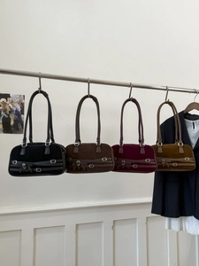 Close-up of suede shoulder bags in black, brown, wine, and khaki with belt buckle detail