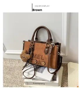 Gros plan du sac à main rétro marron avec gaufrage MEL TOAO et breloque ours adorable