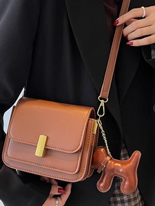 Sac bandoulière vintage en cuir caramel avec fermoir doré et pendentif chiot mignon