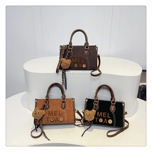 Détails de sacs cabas vintage en noir et marron avec breloques d'oursons en peluche
