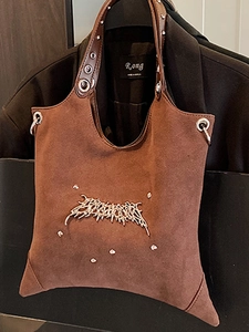 Retro brown distressed tote bag with liquid metal decor and large metal eyelets on strap