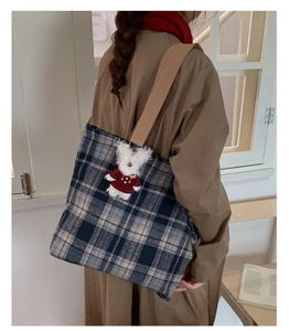 Close-up of vintage blue plaid wool tote bag featuring a cute teddy bear charm