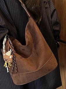 Brown faux suede hobo bag for women with a vintage crossbody style and bear charm accessory
