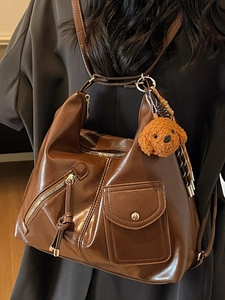Large brown leather shoulder bag with vintage pockets and cute puppy charm for women