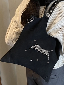 Asymmetrical black canvas tote bag with gothic silver rivets and hardware details