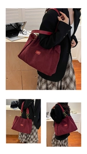 Detailed macro view of burgundy suede tote bag with golden chain handle and metal brand tag