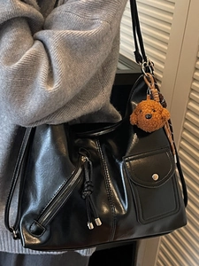 Large black glossy tote bag with teddy charm shown on shoulder for causal daily style