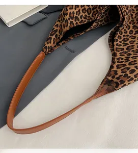 Close-up of the leopard print pattern and brown leather handles on this stylish tote bag