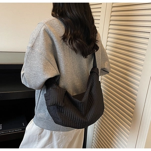 Dettaglio di una grande borsa a tracolla trapuntata nera a mezzaluna in tessuto nylon
