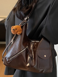 Large dark brown oil wax leather shoulder bag with plush bear charm and silver hardware