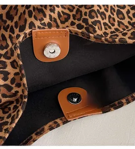 Close-up of leopard print canvas tote bag featuring magnetic buckle and leather fastener