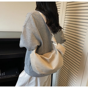 Dettaglio della borsa a pieghe color crema con pochette coordinata e ampia capacità interna