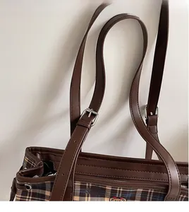 Detail of adjustable long shoulder strap on a vintage plaid tote bag with bear embroidery