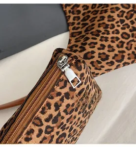 Detail of smooth silver metal zipper on leopard print tote bag with suede texture