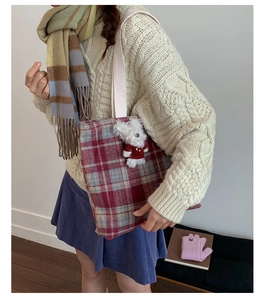 Detail of vintage plaid wool tote bag with a cute white plush bear charm accessory