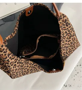 Leopard print tote bag interior view showing zipped compartment and brown leather handles