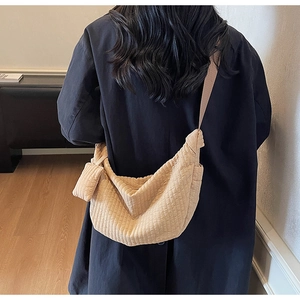 Dettaglio della borsa a mezzaluna in velluto beige con pieghe e mini pochette coordinata