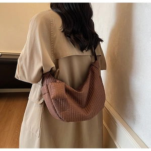Dettaglio della borsa tote plissettata marrone con texture e mini borsa portamonete