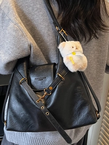 Retro black leather shoulder bag for women with gold hardware and a cute white bear charm