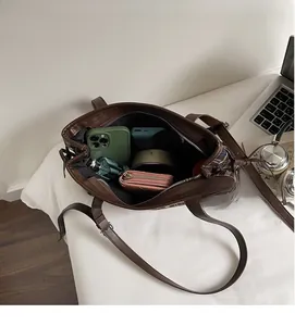 Spacious interior of brown plaid tote bag showing compartments for laptop and daily items
